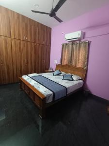 a bedroom with a bed in a purple room at Christmas Rajan Home Stay in Tirunelveli