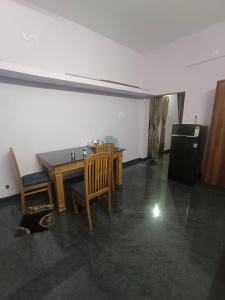 a dining room with a table and chairs and a refrigerator at Christmas Rajan Home Stay in Tirunelveli