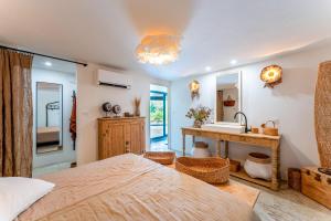 Un dormitorio con una cama, un lavabo y un espejo. en Maisonk Provence, en Villedieu