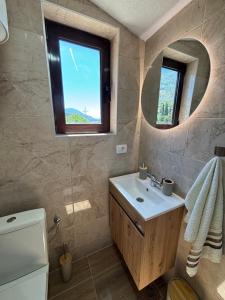 a bathroom with a sink and a mirror at Villa Mia apartments in Sutomore +200 photos