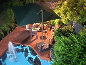 an umbrella sitting on a deck next to a pool at Paju Sabai Pension in Paju