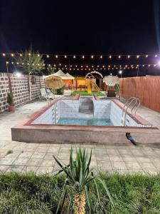 a swimming pool in a backyard at night at Hovakimyans Hotel And Pool Airport in Armavir