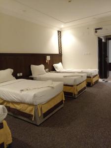 a room with three beds in a room at فندق عبير الفضيلة in Al Masfalah