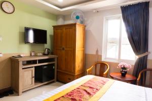 a bedroom with a bed and a cabinet and a tv at Hoang Anh Star Boutique Hotel in Ho Chi Minh City