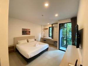 una camera da letto con un letto bianco e una finestra di Double J Hotel a Chiang Mai
