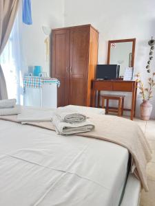 a bedroom with a bed and a wooden cabinet at Aegean Star Hotel in Karavostasi