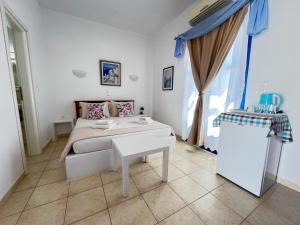 a bedroom with a bed and a table in it at Aegean Star Hotel in Karavostasi