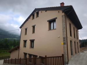 a large white house with a wooden fence at La Casa de La Villa by Casas de Los Picos in Panes