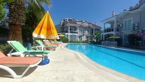 een zwembad met ligstoelen en een parasol bij Baba View Apart in Fethiye +22 foto's