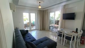 een woonkamer met een blauwe bank en een tafel bij Baba View Apart in Fethiye