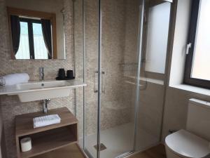 a bathroom with a shower and a sink and a toilet at La Casa de La Villa by Casas de Los Picos in Panes +21 photos