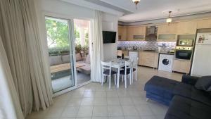 een woonkamer en een keuken met een tafel en stoelen bij Baba View Apart in Fethiye