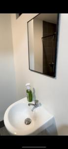 a bathroom sink with a mirror and a soap dispenser on it at Davao Condo Near Airport & Malls in Davao City