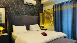 une chambre avec un lit avec un oreiller rouge dessus dans l'établissement Executive 1BHK with Scenic Balcony View & Free Netflix, à Rawalpindi