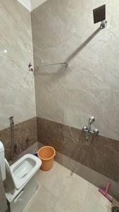 a bathroom with a toilet and a sink at Hotel Anjali Palace in Jāmb