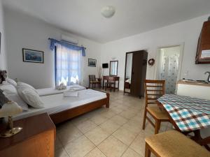 a bedroom with a large bed and a table and chairs at Aegean Star Hotel in Karavostasi