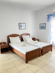 two beds sitting next to each other in a room at Aegean Star Hotel in Karavostasi