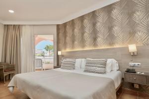 a bedroom with a large white bed with two pillows at Hotel Puerto Palace in Puerto de la Cruz