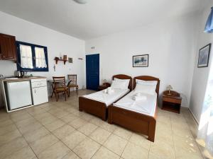 a bedroom with two beds and a kitchen with a table at Aegean Star Hotel in Karavostasi