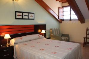 1 dormitorio con 1 cama y 1 silla en Casa Rural Maribel II, en Cue