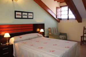 1 dormitorio con 1 cama y 1 silla en Casa Rural Maribel II en Cue