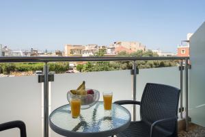 a table with two glasses of orange juice on a balcony at Apartments Chania in Chania