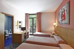 Una habitación de hotel con dos camas y un lavabo. en Cuatro Naciones, en Barcelona 101 fotos más
