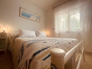 a white bed in a room with a window at Casa Salacia in Nettuno