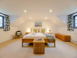 オックスウィッチにある4 Bed in Oxwich 74984の大きなベッドと2つの窓がある寝室