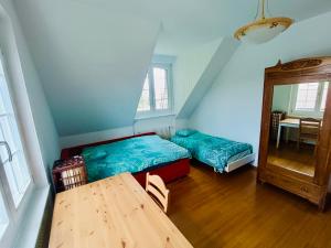 a room with two beds and a table and a mirror at Paradis proche du lac et du campus EPFL in Ecublens