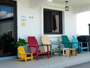 a group of colorful chairs sitting outside of a building at Buan Hwayangyeonhwa Pension in Buan