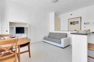 un soggiorno con un divano e un tavolo di Navigli - Porta Ticinese - Luminoso monolocale a Milano