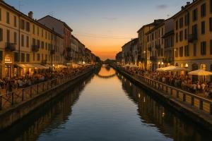 un canale in una città con persone sedute su un ponte di Navigli - Porta Ticinese - Luminoso monolocale a Milano