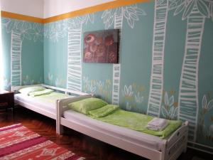 a bedroom with two beds in a room with blue walls at Centar Guesthouse in Zagreb