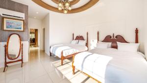 a bedroom with two beds and a mirror and a chandelier at Gapyeong Santa Maria Dog-friendly Privat in Gapyeong
