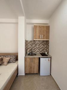 a small kitchen with a sink next to a bed at Villa Mia apartments in Sutomore