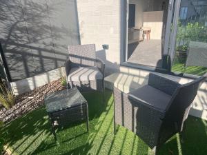 a patio with two chairs and a table and a chair at Cozy 1 BR 1 Bathroom studio in Christchurch