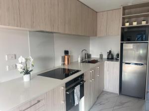a kitchen with white counters and a refrigerator at Cozy 1 BR 1 Bathroom studio in Christchurch