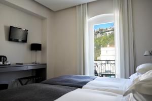 a hotel room with a bed and a window at Hotel Mar Bravo in Nazaré