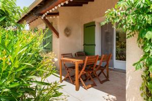 a wooden table and chairs on a patio at Lou Cigaloun in Bédoin
