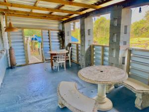 a room with a table and chairs on a porch at Little Rock Inn in Somerset East