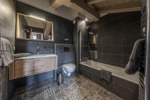 a bathroom with a sink and a toilet and a tub at 4 Bedrooms Penthouse in Courchevel 1650 in Courchevel