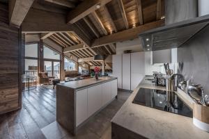 a kitchen with wooden ceilings and a large kitchen island at 4 Bedrooms Penthouse in Courchevel 1650 in Courchevel