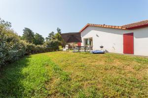 a backyard with a table and an umbrella at Maison Goxoki - En plein coeur du Pays Basque in Saint-Palais