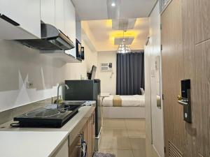 a kitchen with a sink and a room with a bed at Modern Cozy Studio in Dasmariñas