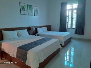 een slaapkamer met twee bedden en een raam bij GolDen RiCe in Thái Thụy