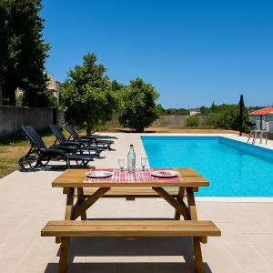 una mesa de picnic de madera junto a una piscina en Spacious House with Private Pool Kitchen, en Teixoso