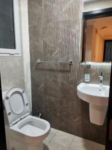 a bathroom with a toilet and a sink at Saray Musheireb Hotel Suites and Apartment in Doha