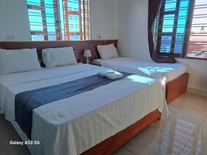 twee bedden in een kamer met ramen bij GolDen RiCe in Thái Thụy