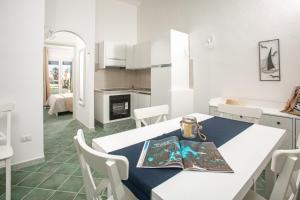 a kitchen and dining room with a table and chairs at BILANCIA VI 30' Porto Cervo & PRIVATE TERRACE with Sea View in Santa Teresa Gallura